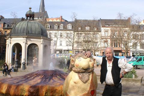 Seit 40 Jahren setzt sich der Wiesbadener Heimatforscher Jürgen Heller für den Riesen Ekko ein. Hier steht er mit dem Maskottchen der Stadt am Kochbrunnen. Foto: Heller