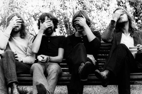 Richard Wright, Nick Mason, Roger Waters und David Gilmour von Pink Floyd bedecken auf einer 1971 in Londons Belsize Park entstandenen Aufnahme ihre Gesichter.