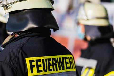 Einsatzkräfte der Feuerwehr tragen auf einem Symbolbild Schutzkleidung.