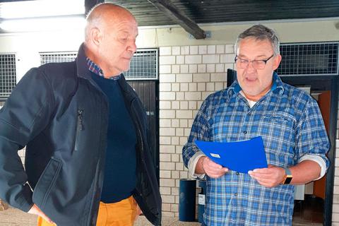 TuS-Vorstand Michael Hövelmann (rechts) verliest die Ehrenurkunde für Bernd Michel. Foto: Constanze Urbano 