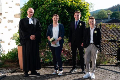 "Dieses Jahr ist alles anders und besonders": Pfarrer Peter Lehwalder mit den drei Konfirmanden. Foto: Kirche 