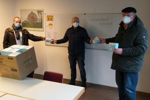 Eine große Kiste mit FFP2-Masken hat Haico Böhmer (Mitte) gespendet. Darüber freuen sich Bürgermeister Ralf Möller (links) und Volker Deußer. Foto: Daniel Seehuber