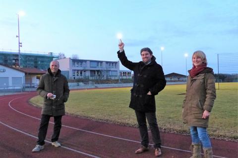 Im Februar 2021 geben Bürgermeister Marius Reusch (Mitte) und Susanne Müller gemeinsam mit Horst Uffelmann von der ausführenden Firma auf dem Rasenplatz in Lang-Göns den Startschuss für die neue LED-Beleuchtung, die deutlich Strom einsparen soll.