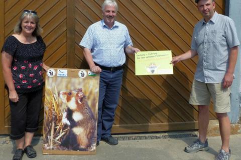 Carola und Uwe Müller freuen sich über die Plakette zum Hamsterschutz, die ihnen Martin Wenisch (r.) überreichte. Foto: Rieger