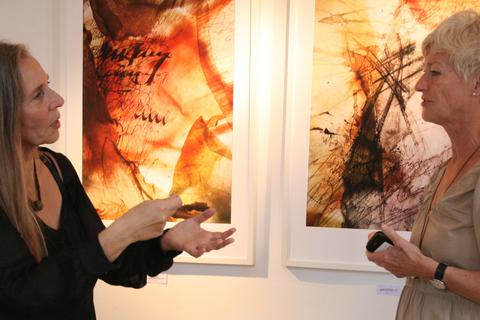 Miriam Bräutigam (links) im Gespräch mit einer Besucherin. Im Hintergrund sind zwei ihrer „geSCHICHTEN“ zu sehen.