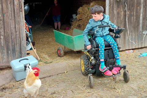 Mit seinem E-Rollstuhl kann sich Finn auf dem Hof gut bewegen und bei der Arbeit mit den Tieren helfen. Kerstin Kaminsky