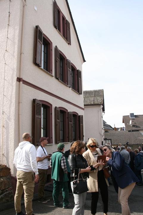 Angehörige grüßen per Videobotschaft ihre Verwandten. Die 86-jährige Lore Lina Löwenstein gehört zu den Opfern und verfolgt so die Verlegung der Stolpersteine aus New Jersey. Im Hintergrund das Haus, in dem Lore Lina geboren wurde und die Familie Löwenstein in Heringen gelebt hat.