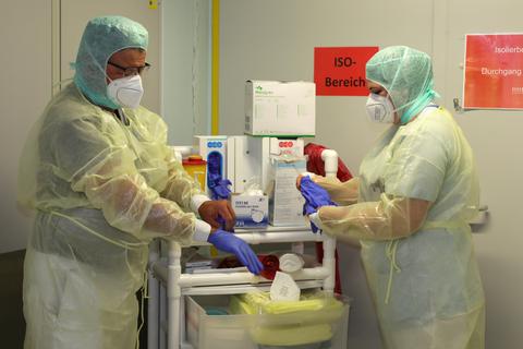 Die Versorgung von Patienten mit Corona ist wegen hohen Anforderungen an den Infektionsschutz aufwendig. Dr. Michael Seng und Stationsleiterin Mona Freisler bereiten sich vor für die Arbeit in der Covid-Normalstation des Kreiskrankenhauses Weilburg.