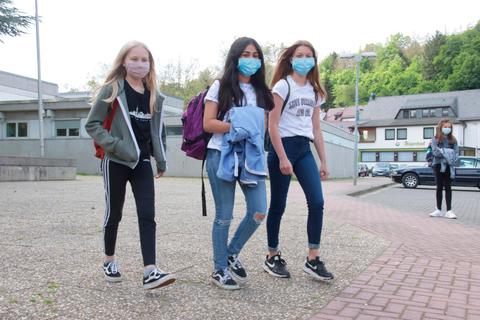 Unter der Maske wird gelächelt: Diese drei Schülerinnen freuen sich, dass sie wieder zum Unterricht in die Weilmünsterer Weiltalschule kommen dürfen, auch wenn die Unterrichtszeiten noch kurz ausfallen.  Foto: Jürgen Vetter 