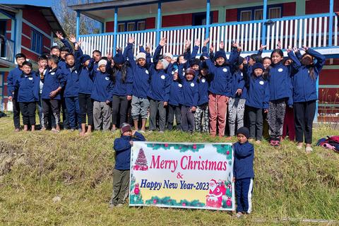 Eine Gruppe von Schülern im nepalesischen Garma wünscht Mitgliedern und Spendern der Himalayan Care Foundation frohe Weihnachten und ein frohes neues Jahr 2023. Die Schüler tragen die neuen Winterjacken, mit denen die mittelhessische Hilfsorganisation bereits 500 Kinder ausgestattet hat. 