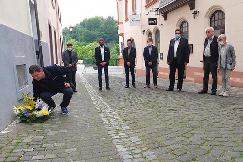Ido Michel legt ein Blumengebinde nieder im Beisein von (v.l.) Pfarrer Hans Mayer, Bürgermeister Johannes Hanisch (CDU), Christian Radkovsky (Geschichtsverein), Stadtverordnetenvorsteher Bruno Götz, Hans-Peter Schick sowie Joachim und Annemarie Warlies (Geschichtsverein). Foto: Sabine Gorenflo 
