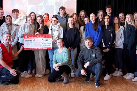Die beiden GPW-Geographie-Leistungskurse bei der Spendenübergabe in der Aula. Vorne kniend links: Hartmut Schotte von "Humedica" sowie auf der rechten Seite Anna-Maria Lotz und Christoph Bickel. © GPW