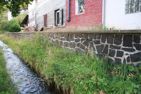 Deutlich zu erkennen sind die Schäden in den Fugen an der Stützmauer am Engelbach. Deren Sanierung hat der Ortsbeirat für den Haushalt 2024 angemeldet.