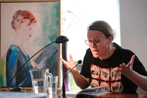 Sandra Lüpkes liest in Niederdieten nicht nur aus ihrem Buch, sie beleuchtet auch dessen historischen Hintergrund. Apropos Hintergrund: Das Bild neben der Autorin hat die Holzhäuser Künstlerin Sibylle Ossenbach-Beinborn extra für die Lesung im "Café Q" angefertigt.