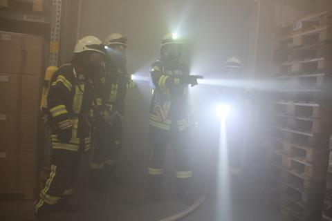 In der vollständig vernebelten Halle fällt den Feuerwehrleuten die Orientierung auch trotz Taschenlampen schwer. 