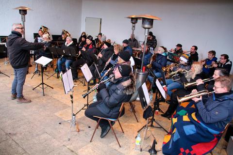 Mit Mützen und unter Heizstrahlern trotzen die Mitglieder des Musikvereins den kalten Temperaturen und  schaffen mit ihren Liedern eine vorweihnachtliche Stimmung. Foto: Sascha Valentin 