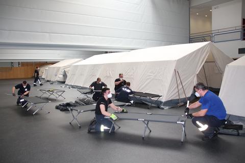 In einer Rekordzeit von nur knapp zwei Stunden haben die Mitglieder der Feuerwehren die Zelte in der Hinterlandhalle aufgebaut und füllendiese mit den Feldbetten. 