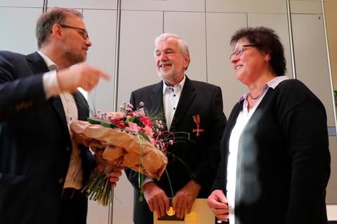 Landrat Jens Womelsdorf (v.l.) überreicht Werner Hesse den Bundesverdienstorden und Blumen für Ute Hesse.  Foto: Florian Lerchbacher 