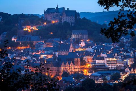 Blaue Stunde in Marburg: Dieses Bild gehört jedoch vorerst der Vergangenheit an - zumindest teilweise. Denn die Stadt strahlt die ihr gehörenden Sehenswürdigkeiten vorerst nachts nicht mehr an. Das wirft jedoch einige Fragen auf.   Foto: Thorsten Richter  