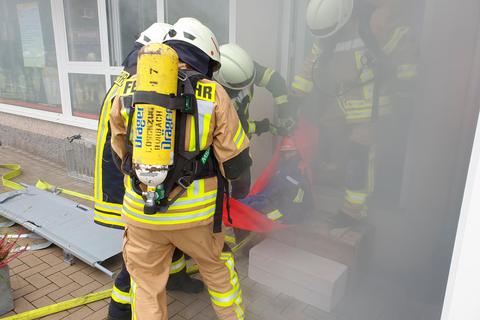 Mithilfe eines Rettungstragetuchs bringen die Feuerwehrleute die "Verletzten" aus dem Gebäude.  Foto: Lutz Schäfer 
