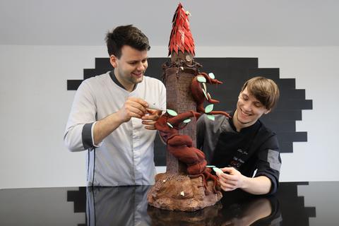 Mehr als 15 Kilogramm schwer, einen Meter hoch und optisch ein echter Hingucker: Felix Vogel (l.) und Jossua Liboni bauen den Bergfried, den höchsten Turm des Braunfelser Schlosses, aus Schokolade nach. Für das Kunstwerk benötigen die beiden Konditoren fünf Tage.