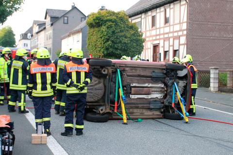 Umgestürzt: Die Feuerwehr muss die in Ewersbach verunglückte Suzuki-Fahrerin aus ihrem Auto befreien. Foto: Frank Rademacher 