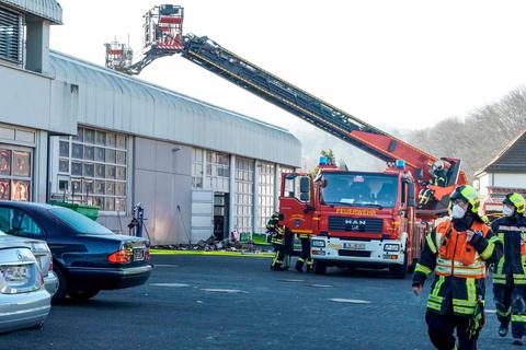 Löschangriff von zwei Seiten: Die Feuerwehren aus Dillenburg und Haiger bekämpfen von ihren Drehleiterfahrzeugen aus den Brand im Dillenburger Autohaus von Mercedes-Bald. Foto: Katrin Weber 