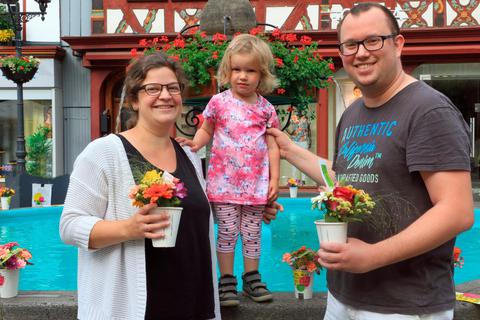 Freuen sich riesig über die bunten Blumensträußchen, die sie am Herborner Marktplatzbrunnen gefunden haben: Marie, die kleine Johanna und Felix Walther. Foto: Siegfried Gerdau 