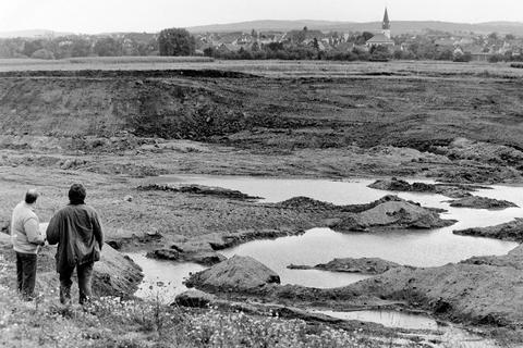 Die Lahnaue - auch auf Atzbacher Gebiet - wurde zwischen 1960 und 1996 als Kiesabbaufläche wirtschaftlich genutzt. Zahlreiche der dabei entstandenen Seen sind geblieben, jener - noch nicht mit Grundwasser vollgelaufene - auf dem Foto von 1989 wurde wieder aufgefüllt und ist damit verschwunden.