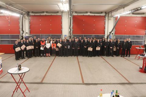 Die insgesamt 92 Feuerwehrleute erhalten ihre Auszeichnung in feierlicher Runde in der Fahrzeughalle der Feuerwehr Herborn. 