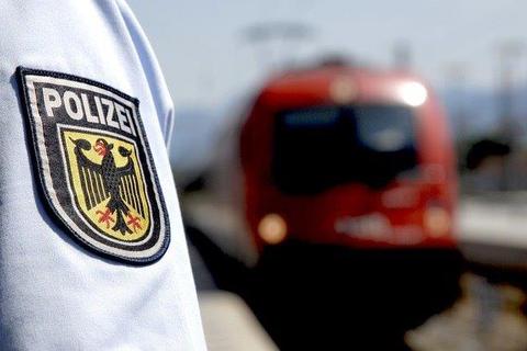 Ein Beamter der Bundespolizei steht an einem Bahngleis.