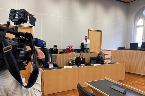Ein 49-Jähriger aus Wetzlar (vorne, links) und ein 67-Jähriger aus Groß-Umstadt (hinten, Mitte) sitzen im Landgericht Limburg mit ihren Verteidigern vor Beginn des Strafprozesses.