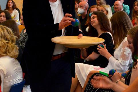Die Tutoren, hier Kunstlehrer Jürgen Kneipp, verteilen kleine Weltkugeln als Erinnerung und Glücksbringer an die Abiturienten der Goetheschule. Foto: Frank Stühler 