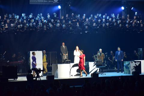 Im Vordergrund der Bühne agieren die Musical-Darsteller, während die 31 Chöre im Hintergrund aufgestellt sind. Foto: Lothar Rühl