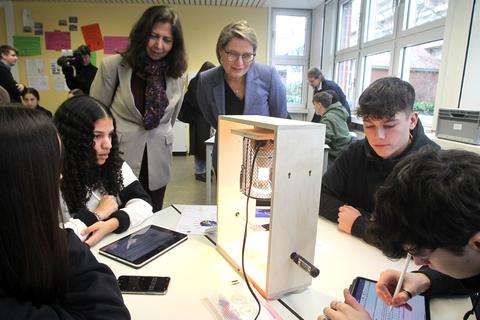 Schüler der IGS in Mainz-Bretzenheim zeigen „Klimakoffer”-Entwicklerin Cecilia Scorza und Bildungsministerin Stefanie Hubig ihren Versuchsaufbau, bei dem sie lernen, was Farben mit Hitze zu tun haben.