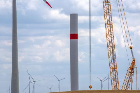 Ein Kran arbeitet auf der Baustelle eines neuen Windparks.