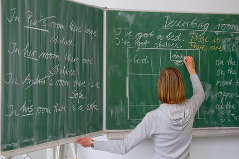 Eine Lehrerin schreibt an die Tafel. Foto: dpa