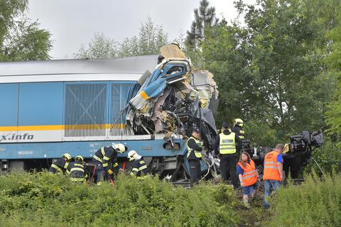 Einsatzkräfte stehen an einem zerstörten Waggon. Ein aus München kommender Expresszug ist in Tschechien mit einem Personenzug zusammengestoßen. Zwei Menschen seien bei dem Unglück ums Leben gekommen, berichtet die Agentur CTK.   Foto: dpa