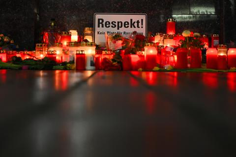 Ein Schild mit der Aufschrift "Respekt" spiegelt sich zusammen mit niedergelegten Kerzen in der nassen Straße am Tatort Heumarkt. Foto: dpa