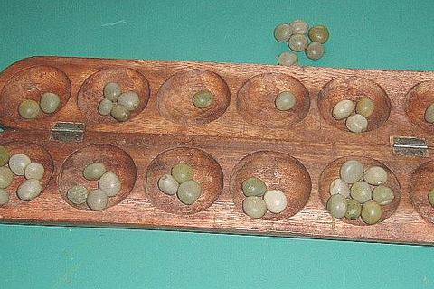 Oware-Brett aus Osese-Holz mit Samen der Molukkenbohne. Foto: de.wikipedia.org/wiki/Benutzer:Peng