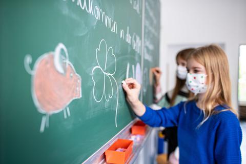Eine Grundschule mit Schülern die Masken tragen. Symbolbild: Guido Kirchner/dpa