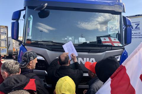 Einigung erzielt: Die 63 Lkw-Fahrer unterschreiben am Mittwoch auf dem A5-Rasthof "Gräfenhausen-West" den Vertrag mit der polnischen Spedition, in dem ihnen alle Zahlungen zugesichert werden.