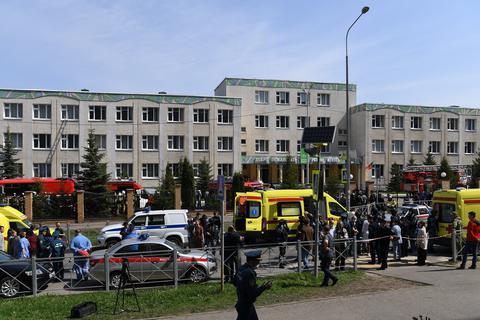 Einsatzkräfte von Polizei und Rettungsdiensten stehen vor einem dem Gymnasium Nummer 175. Bei einem Angriff auf die Schule sind mehrere Menschen getötet worden.  Foto: dpa