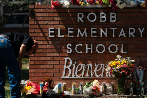 Ein Mitarbeiter der Strafverfolgungsbehörden zündet eine Kerze vor der Robb Elementary School an. Ein 18-jähriger hat bei einem Amoklauf in einer Grundschule im US-Bundesstaat Texas mehrere Menschen getötet.  Foto: Jae C. Hong/AP/dp