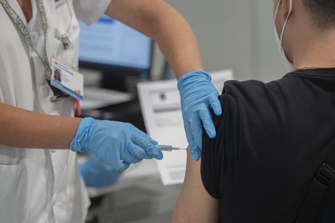 Ein junger Mann wird gegen das Coronavirus geimpft. Foto: dpa