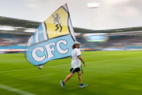Ein Chemnitzer Fan rennt mit einer Fahne vor Beginn des Spiels über den Platz.  Foto: dpa