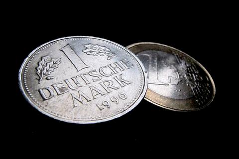 Eine Ein-Euro-Münze und eine Deutsche Mark (D-Mark).  Foto: Karl-Josef Hildenbrand/dpa