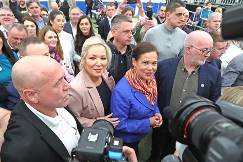 Mary Lou McDonald (Mitte r), Vorsitzende der nordirischen Partei Sinn Fein, und Michelle O'Neill (Mitte l), Spitzenkandidatin der nordirischen Partei Sinn Fein, treffen im Auszählungszentrum für die Wahlen zur Nordirischen Versammlung in der Meadowbank Sports Arena ein. Foto: Liam Mcburney/PA Wire/dpa