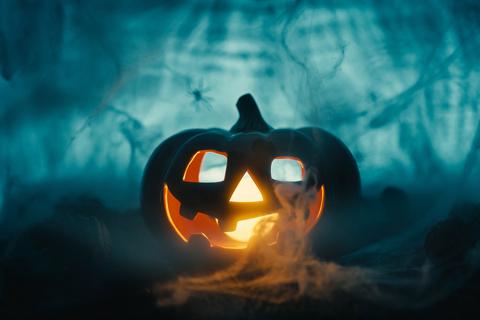 Halloween-Kürbis mit Spinnennetz und beängstigendem Hintergrund