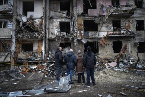 Menschen betrachten die Schäden nach einem Raketenangriff auf ein Wohnhaus. Russland hat am Donnerstag einen umfassenden Angriff auf die Ukraine gestartet und Städte und Stützpunkte mit Luftangriffen oder Granaten beschossen.  Foto: dpa